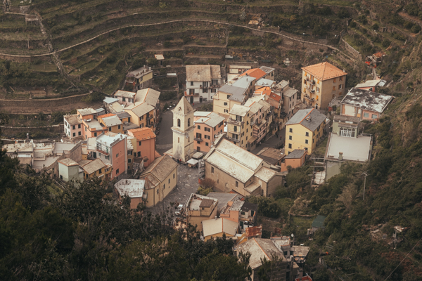Looking down over the rooftops of Manarola from the trail above, terraced hillsides surrounding the village