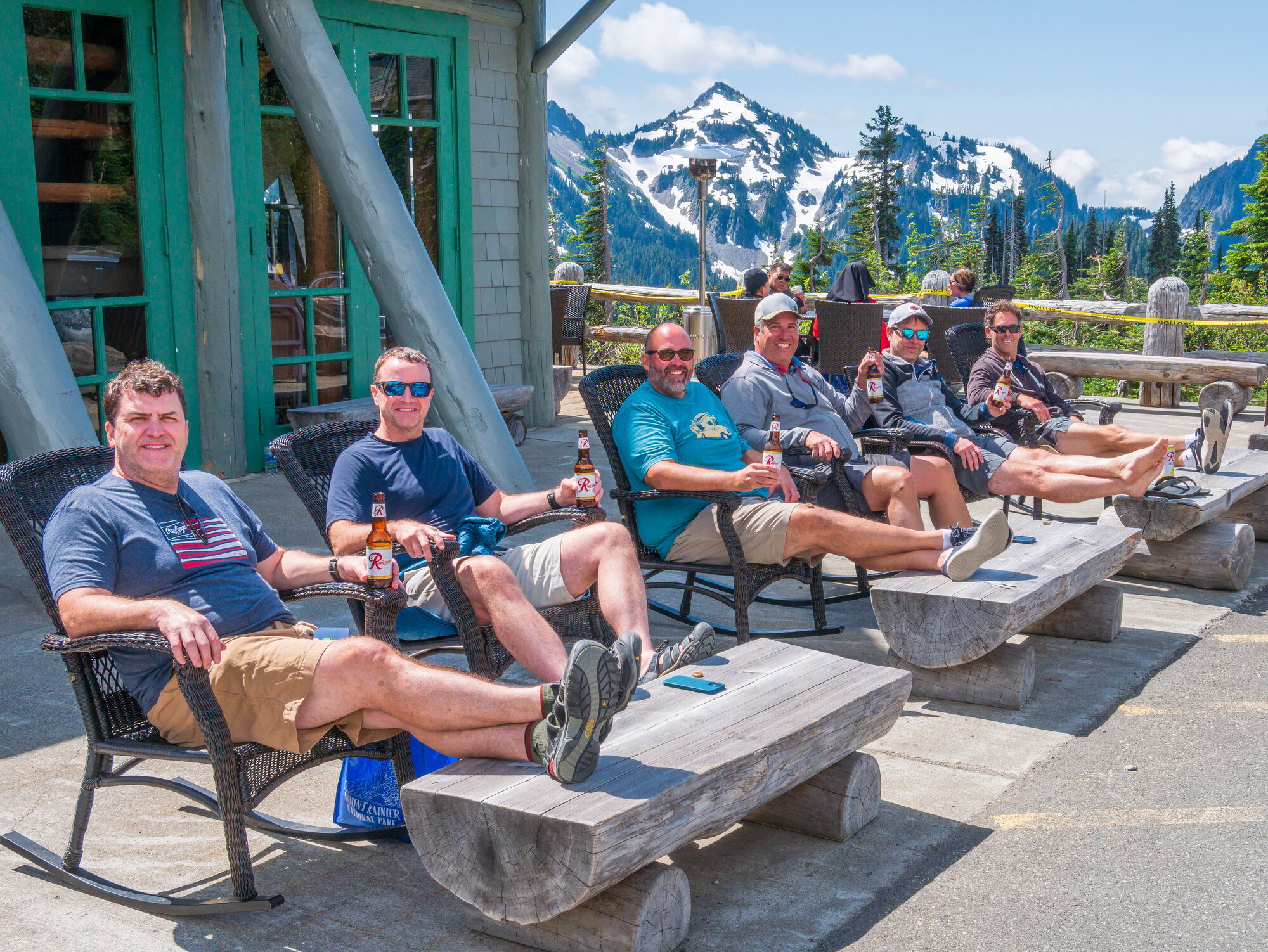 Group relaxing with Rainier beer on the Paradise Lodge patio, Tatoosh Range rising behind