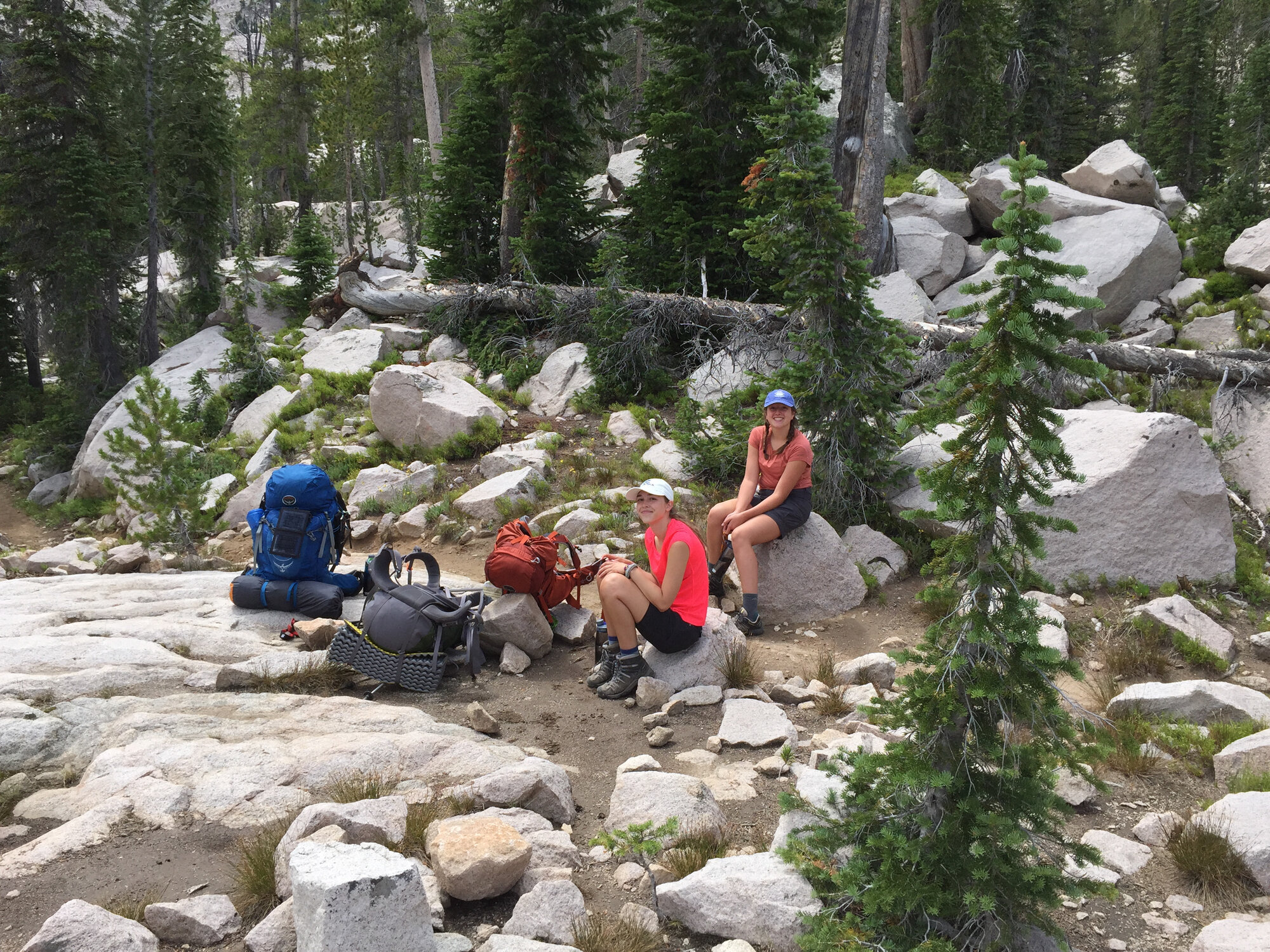 Two hikers resting on granite boulders in the Sawtooth backcountry